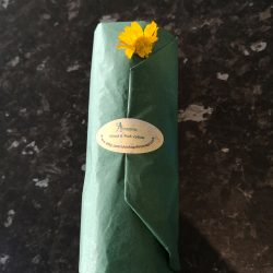 Green tissue paper packaging for Hand and Foot lotion with flower embellishment