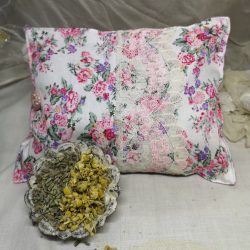 Floral pink herbal pillow with a dish of dried chamomile and lavender