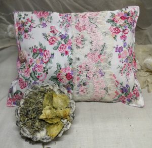 Pink floral herbal pillow with a dish of hops and lavender