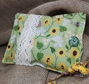 a pretty green and yellow herbal pillow with sunflowers and bee detail